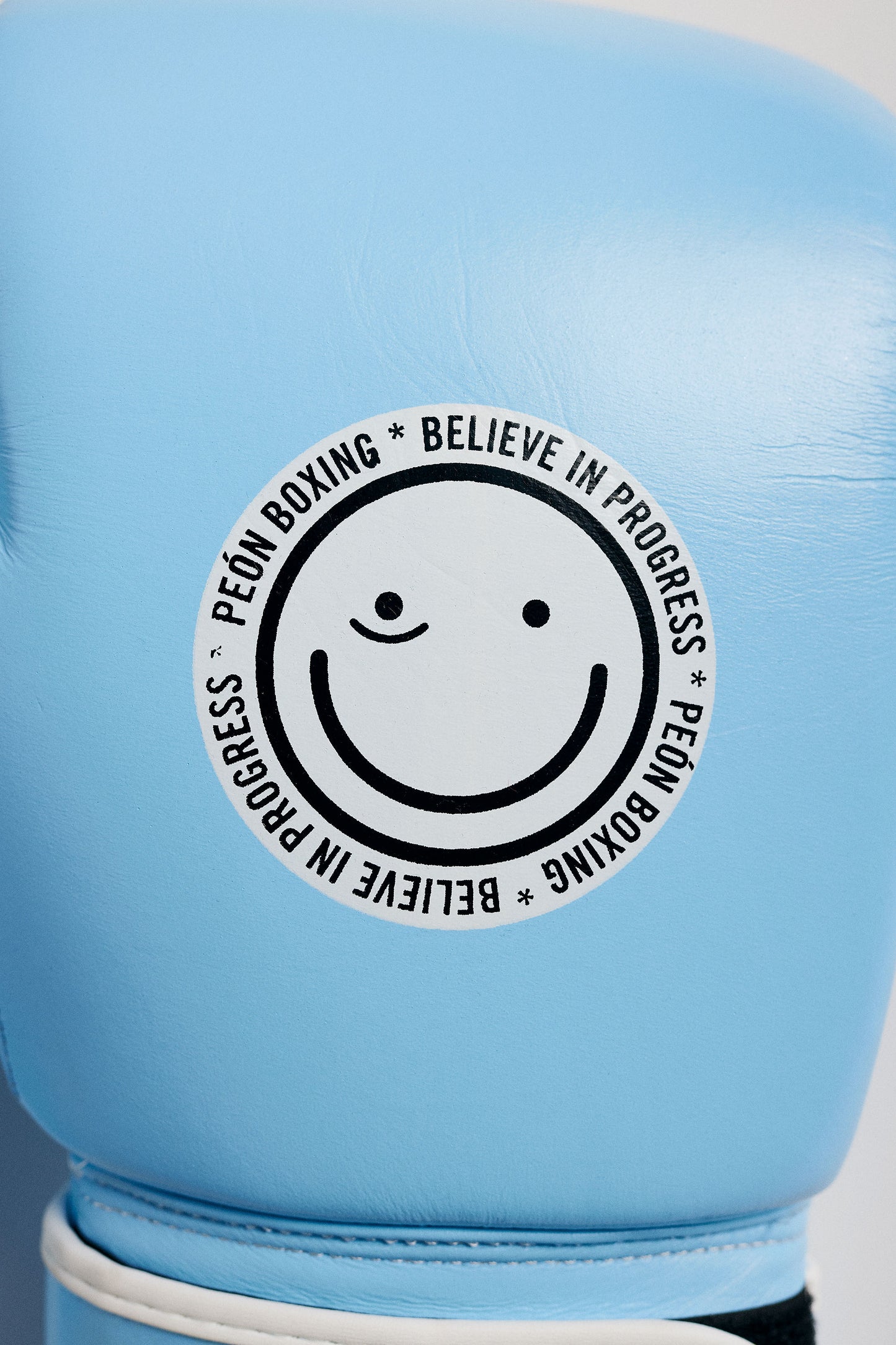 baby blue boxing glove with smile logo