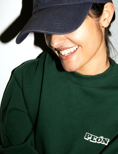 girl smiling with an green sweatshirt and black cap on